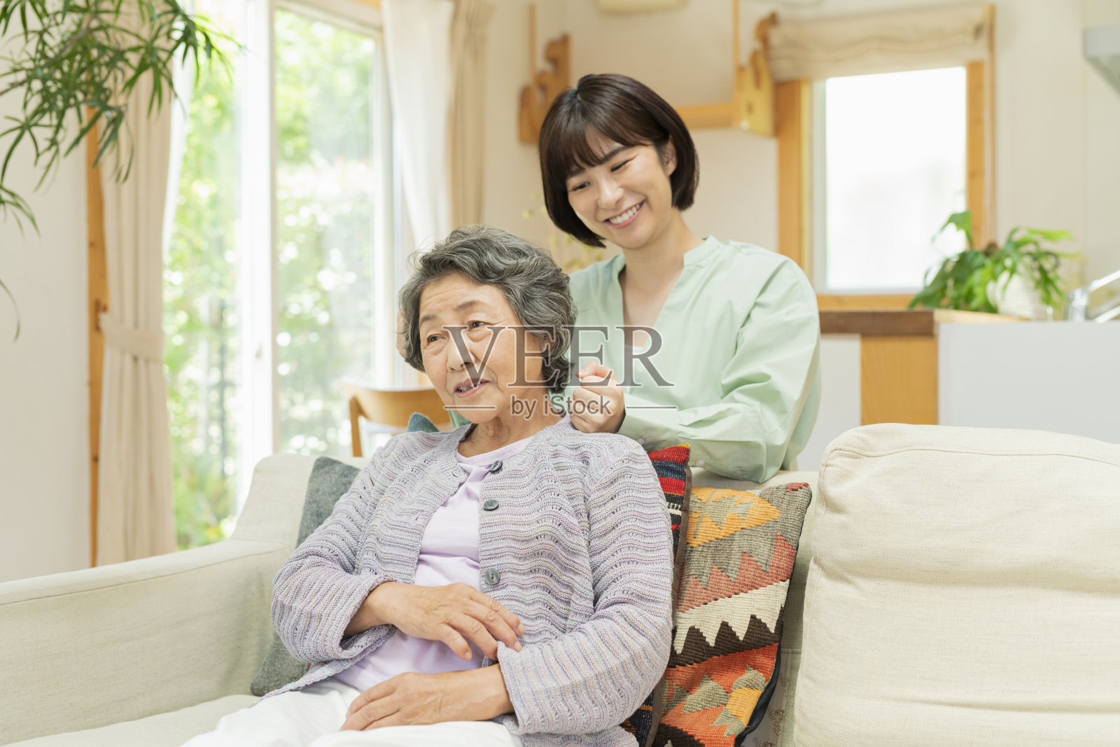 30多岁的女人在揉祖母的肩膀。照片摄影图片