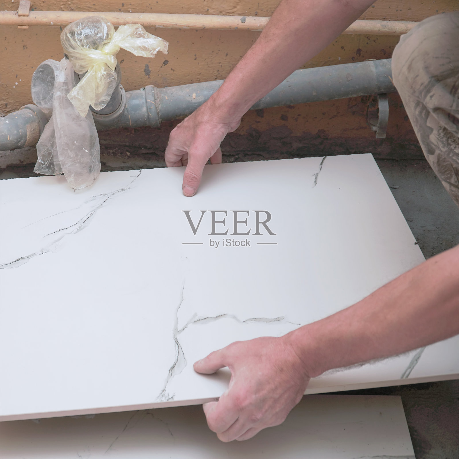 一名男建筑工人铺地板瓷砖照片摄影图片