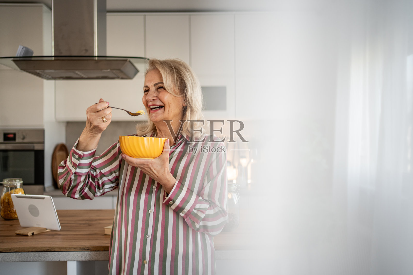 每一口都让人感到舒适——一位退休老人吃着玉米片照片摄影图片