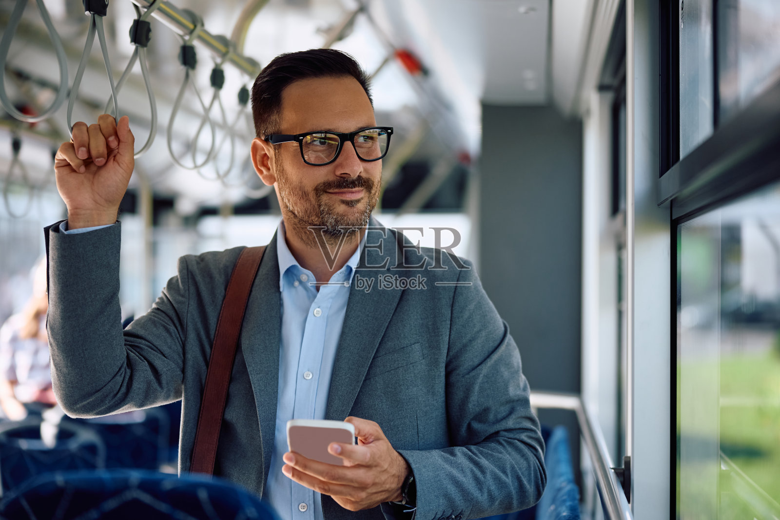 微笑的商人乘公交车去上班。照片摄影图片