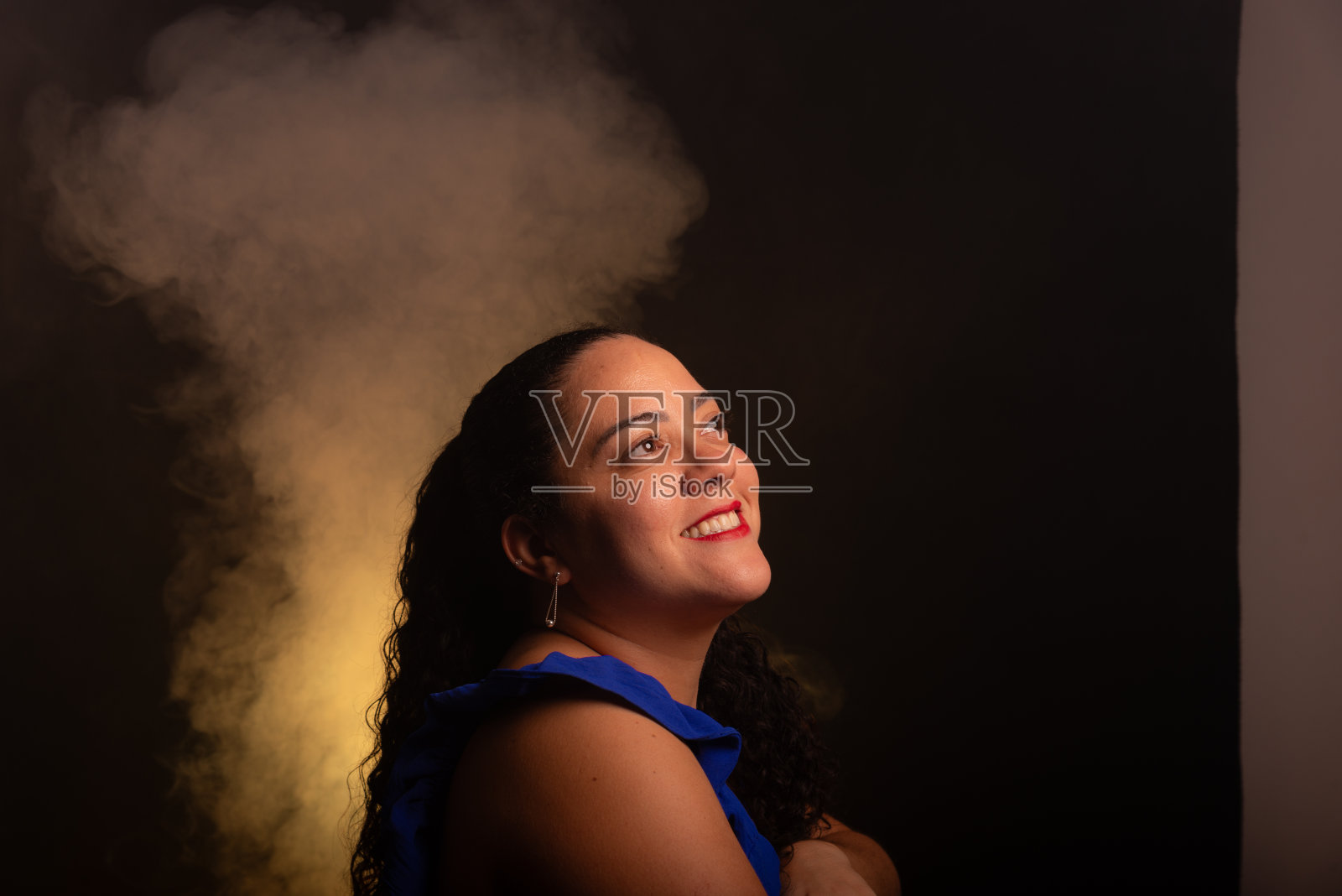 穿着蓝色衬衫的美女在拍照时看着左边。照片摄影图片