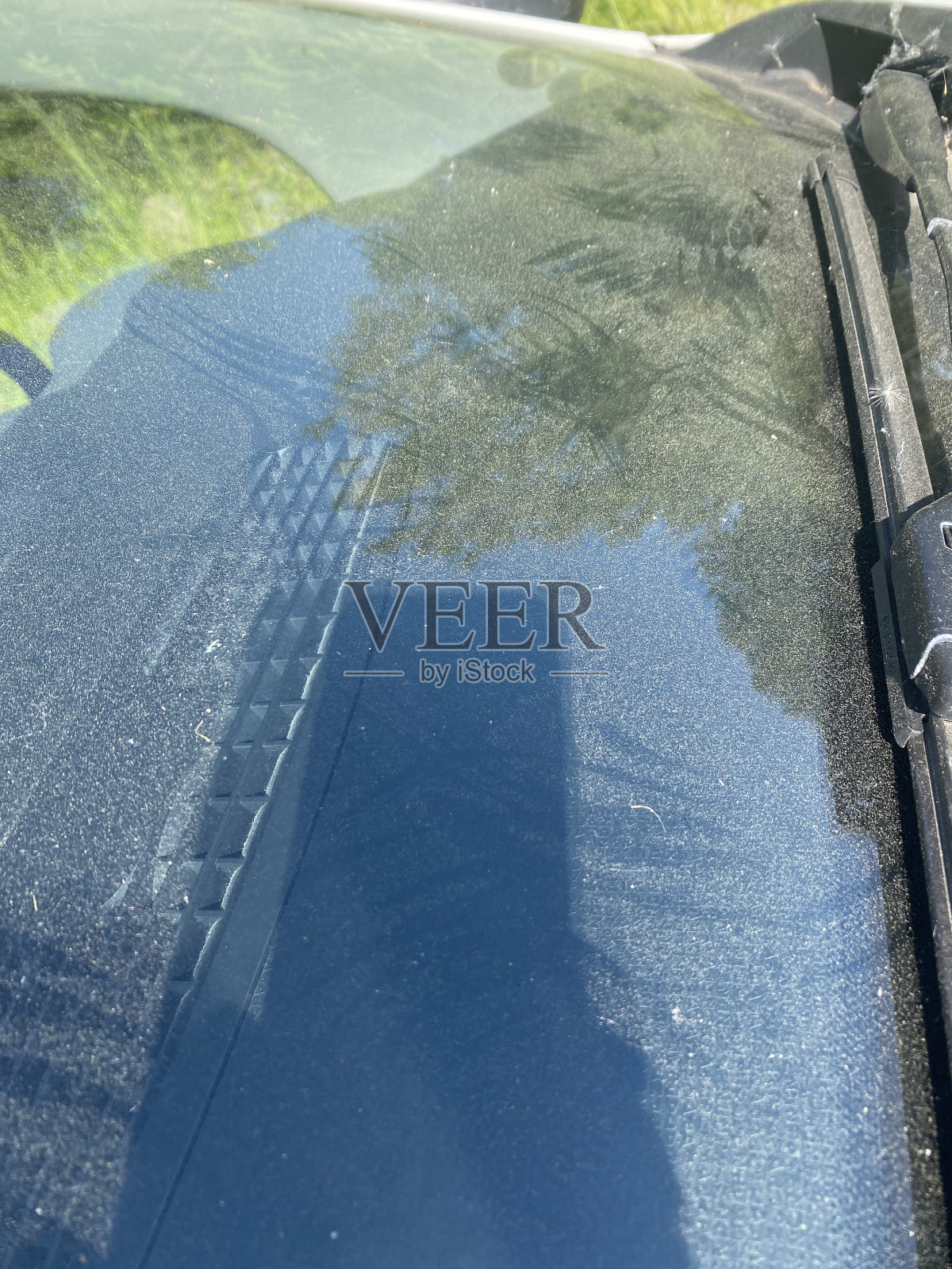 满是灰尘的汽车前窗上有鸟翅膀的印迹。照片摄影图片