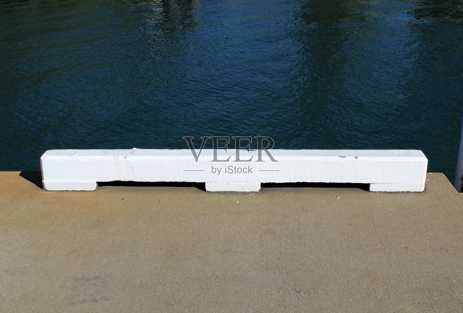 靠近大海的混凝土码头上的白色木块照片摄影图片