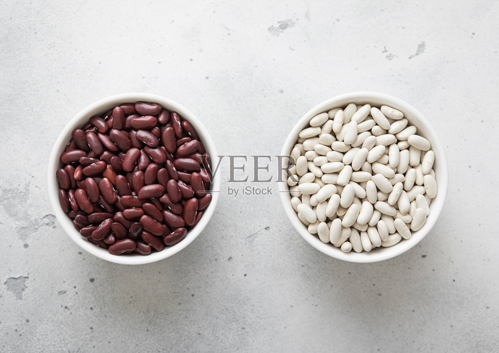 厨房餐桌上有白色和红色生干豆的陶瓷碗。宏观。照片摄影图片