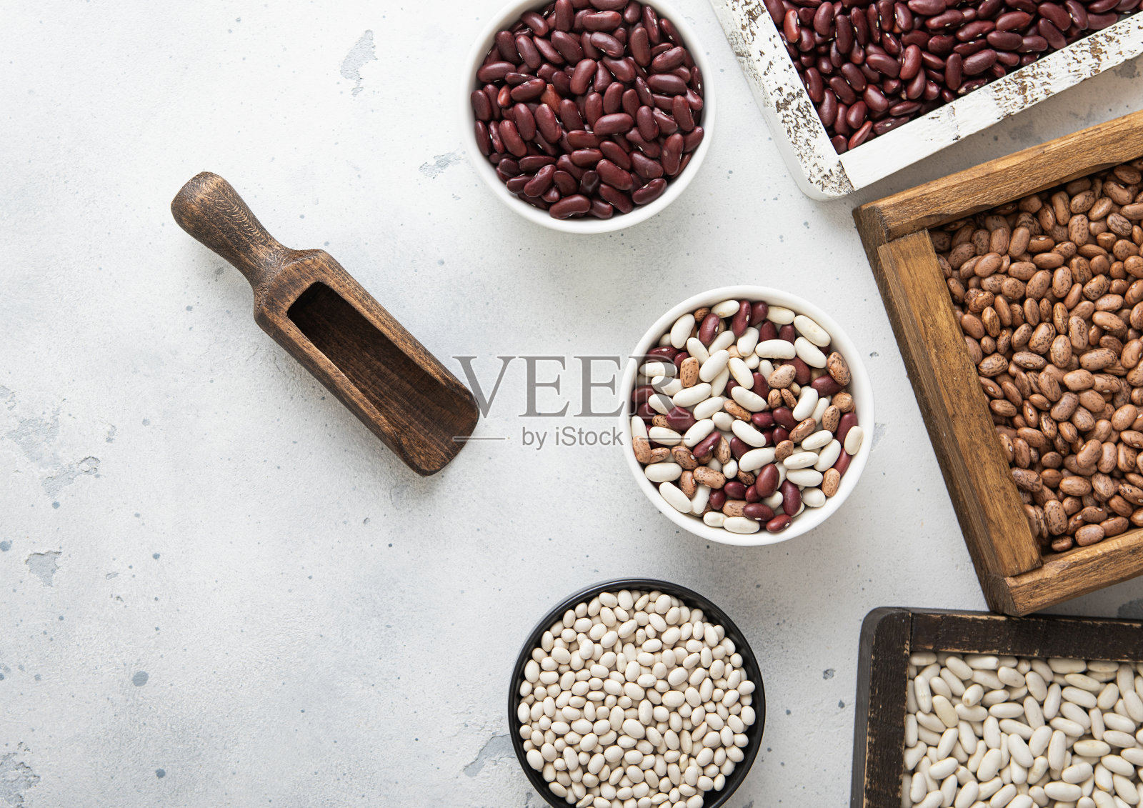 干燥的生白豆，红豆和混合豆，放在陶瓷碗和木箱里，放在浅色的桌子上。照片摄影图片