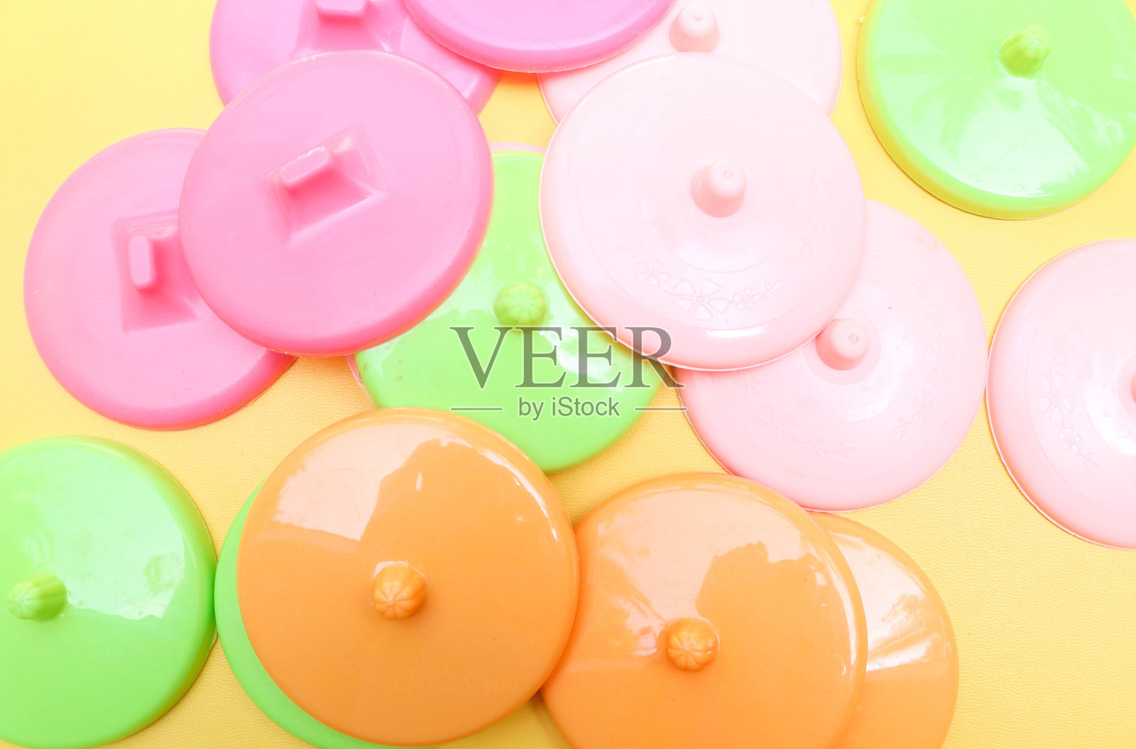收集彩色塑料杯盖孤立在一个黄色的背景照片摄影图片