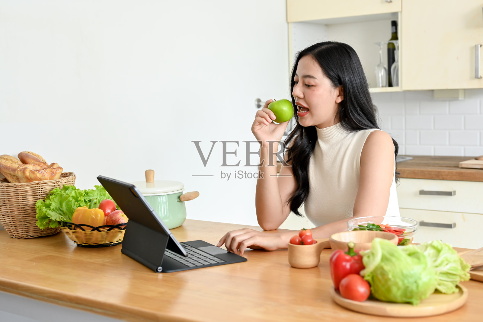 漂亮的年轻女子在现代厨房里吃新鲜沙拉的肖像照片摄影图片