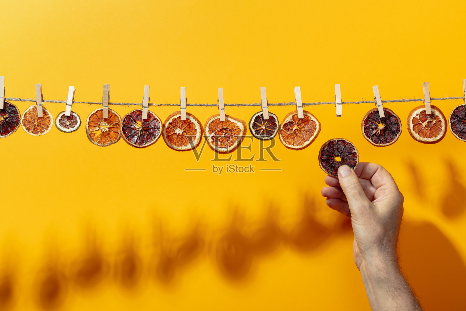 橙子、柠檬和酸橙片在一条线上晒干。照片摄影图片