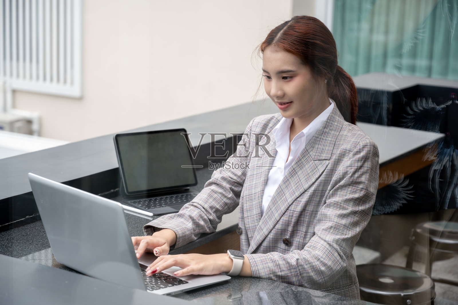 一位女商人在咖啡馆用平板电脑和智能手机远程办公照片摄影图片