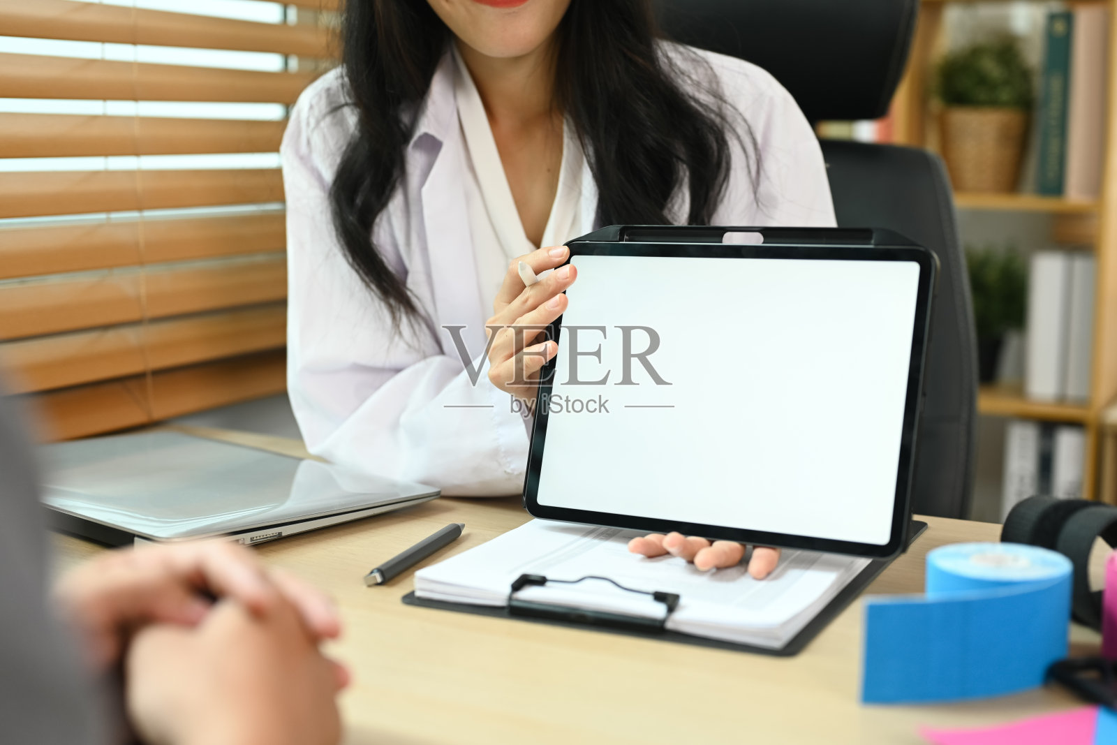 物理治疗师一边与病人交谈，一边在平板电脑上解释一些事情照片摄影图片