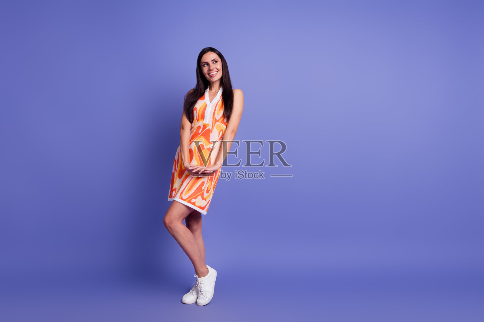 漂亮女士的全身画像看起来空无一物，认为穿衣服孤立在紫色的背景上照片摄影图片