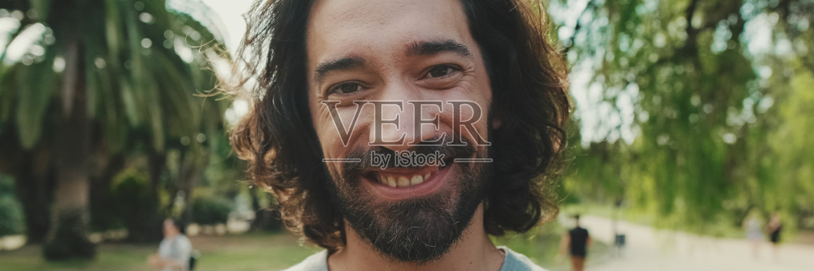 近距离看，年轻人抬起头，看着镜头微笑，全景照片摄影图片