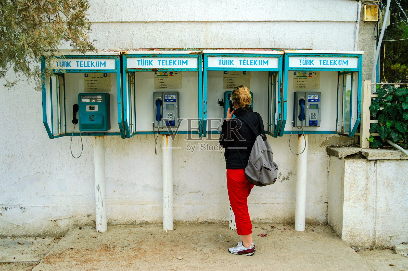 土耳其一名女游客背着双肩包站在公共电话旁照片摄影图片