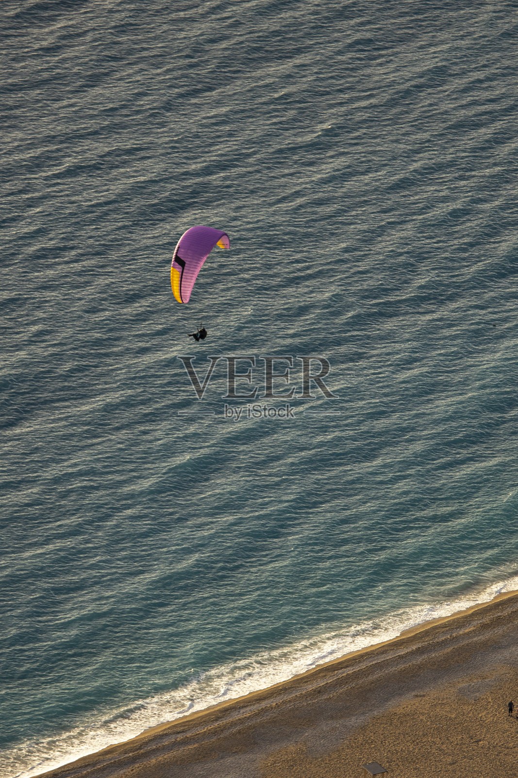 滑翔伞从babadaku降落到Ölüdeniz。背景蓝色的大海和海滩照片摄影图片