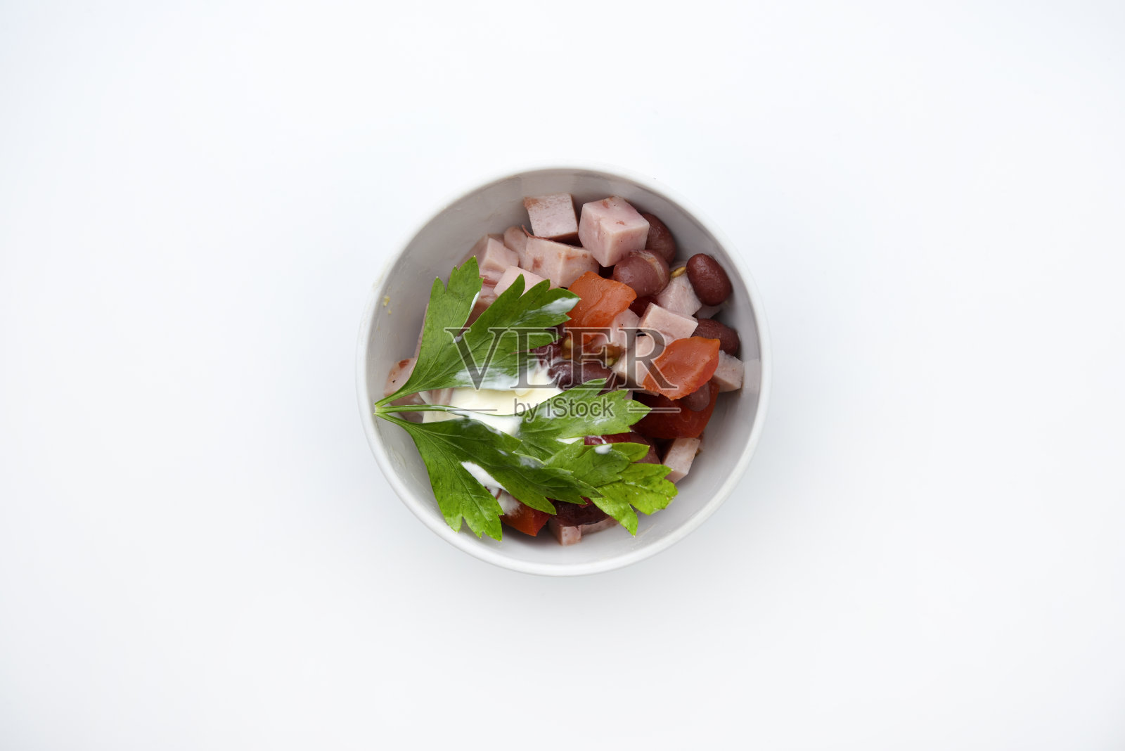 蔬菜沙拉，肉和酱在一个白色的沙拉碗。小点心。照片摄影图片