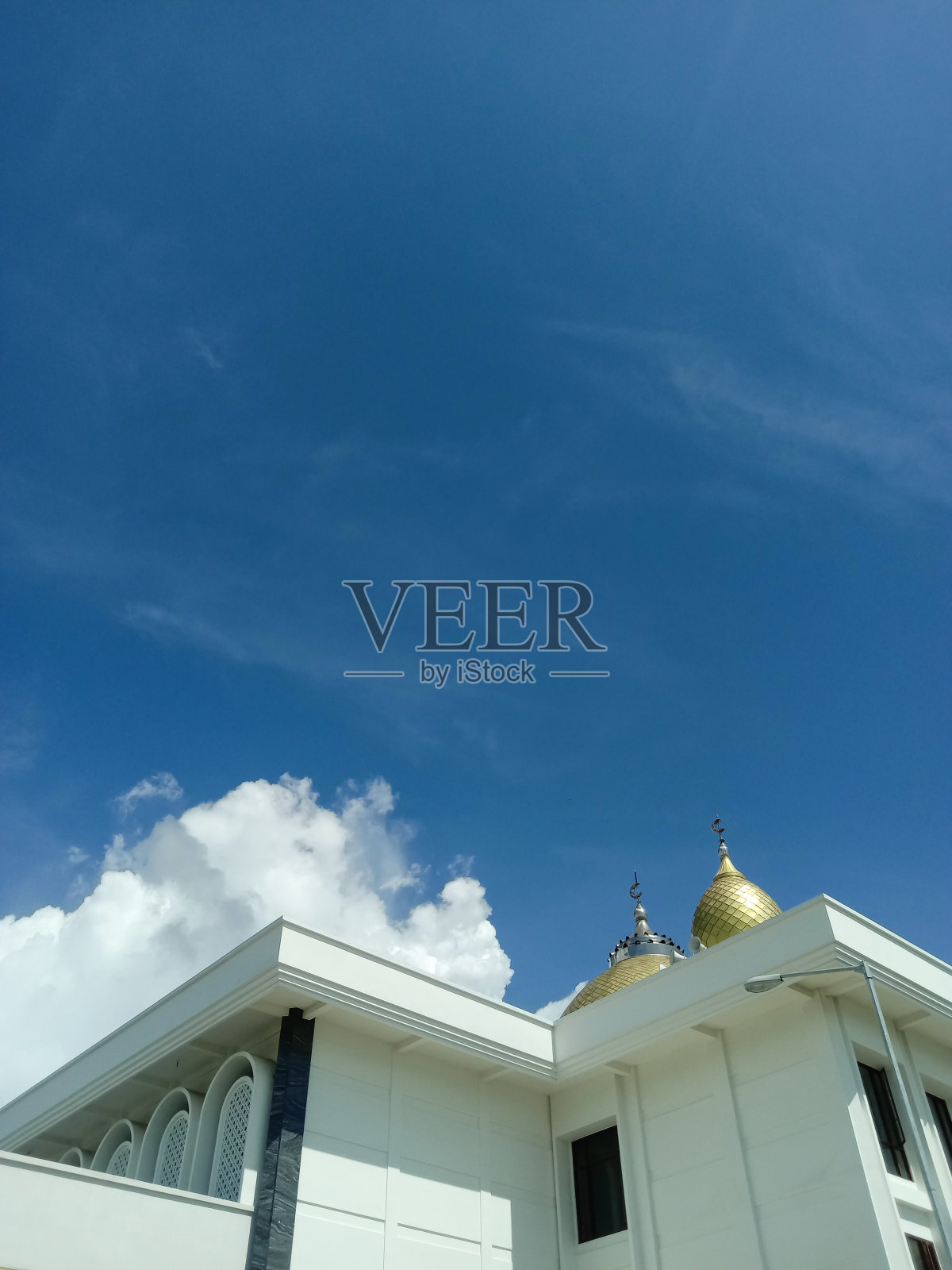 一座白色的清真寺建筑，背后是明亮的蓝天照片摄影图片