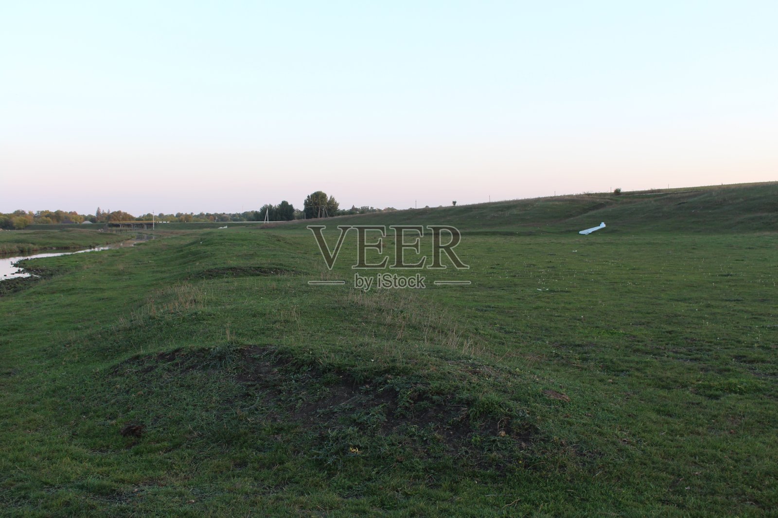 远处有一片草地和一片水域照片摄影图片