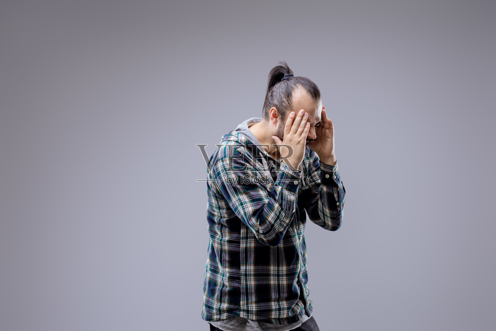 络腮胡男人头痛难忍，按住太阳穴照片摄影图片