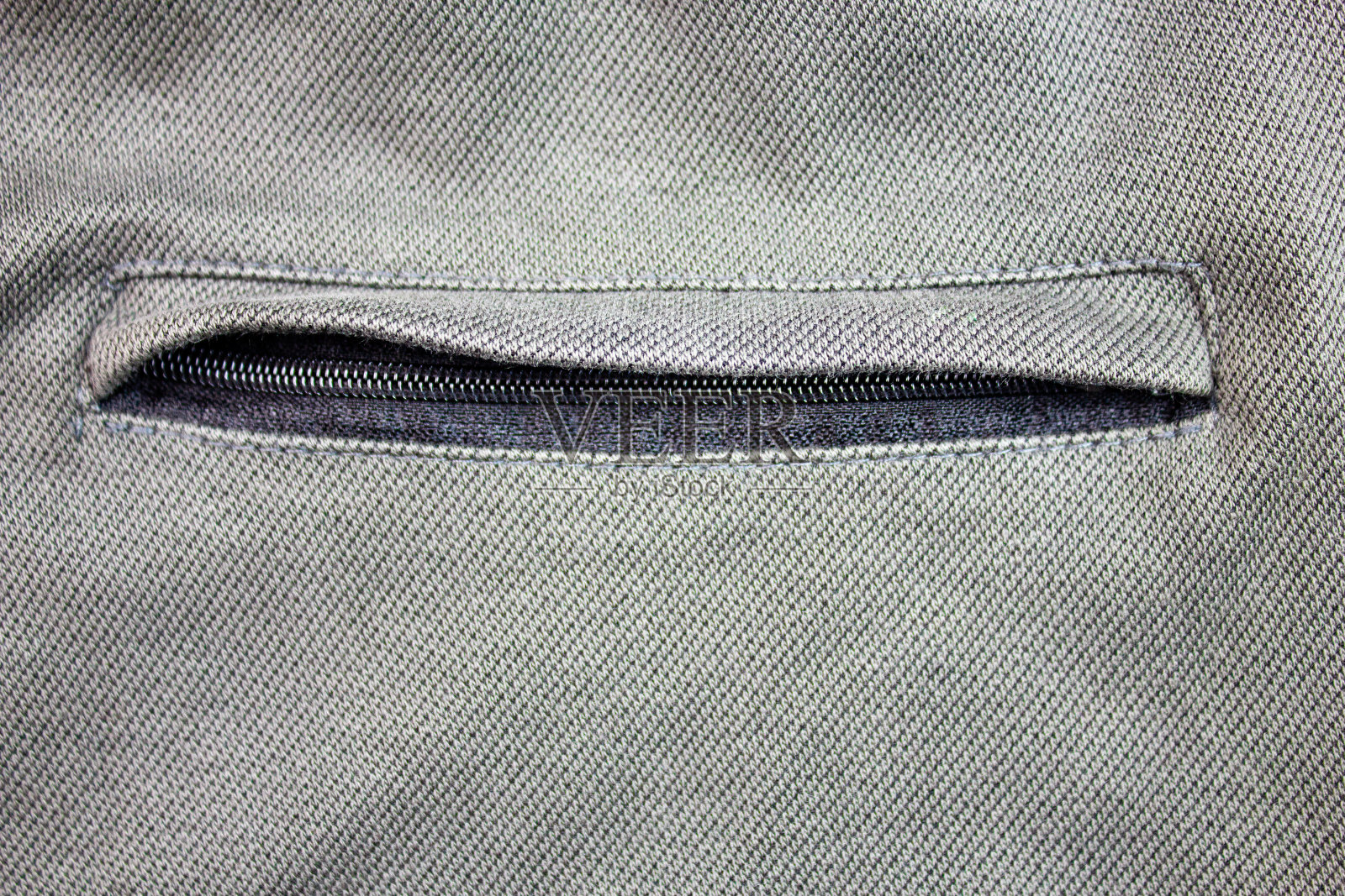 拉链口袋。绿色运动裤上有纽扣的口袋。照片摄影图片