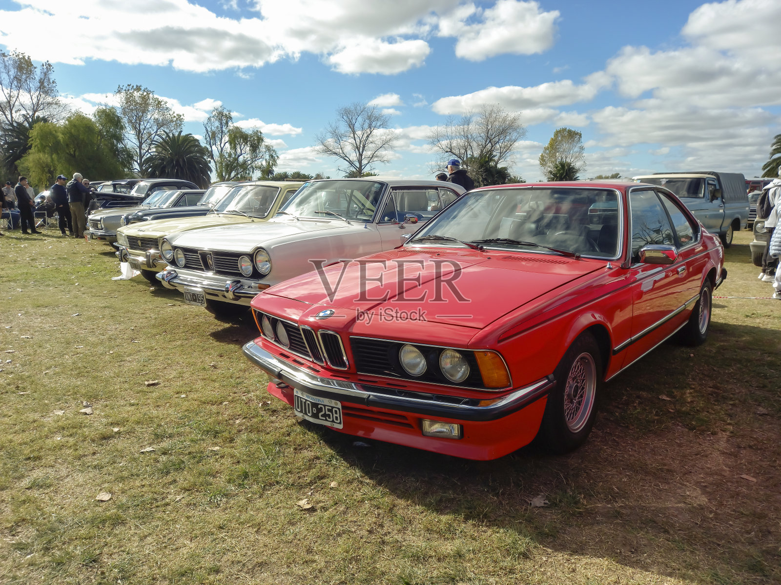 20世纪80年代的红色宝马6系635双门轿跑车停在公园经典车展的草坪上照片摄影图片