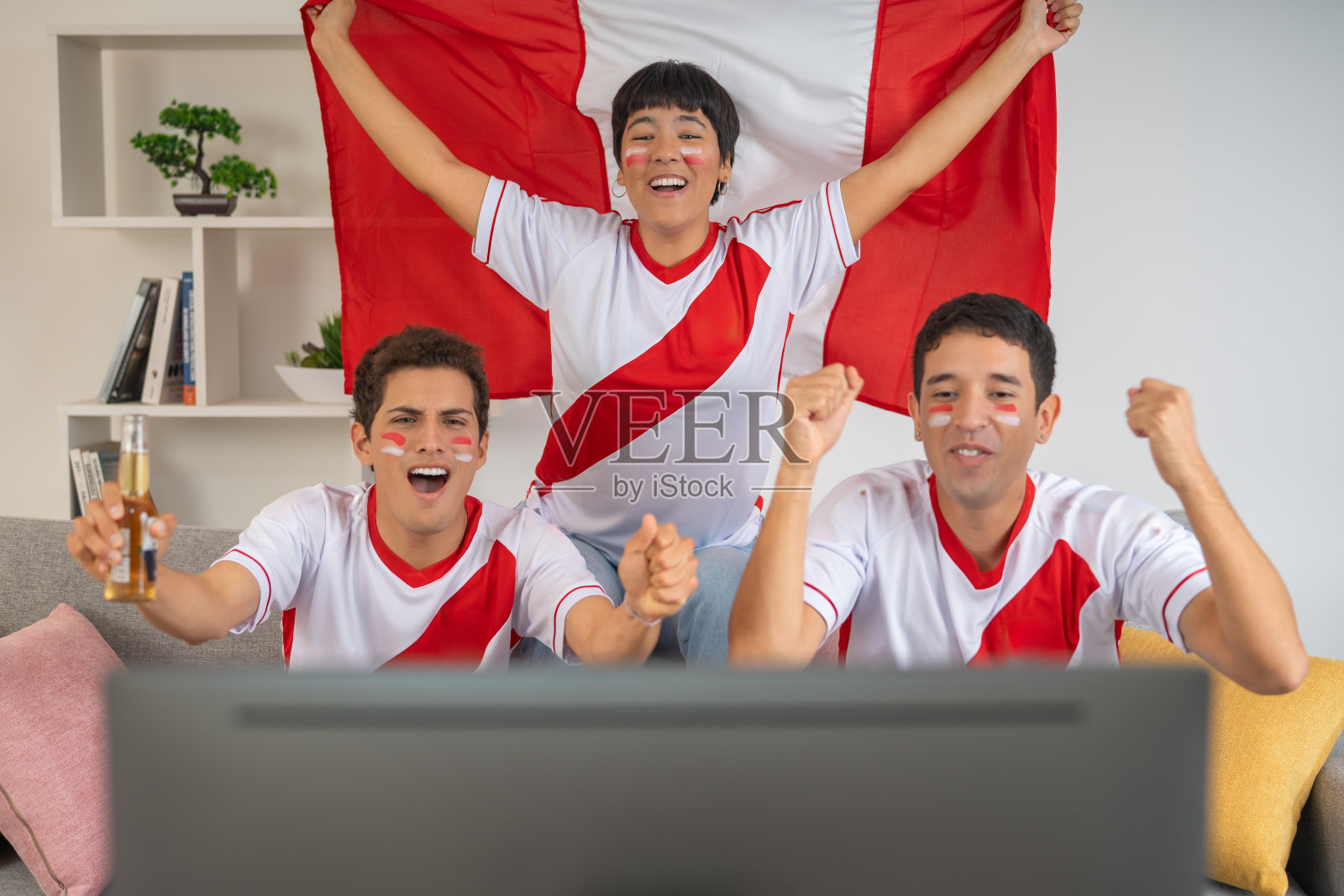 快乐的朋友在电视上看足球比赛照片摄影图片