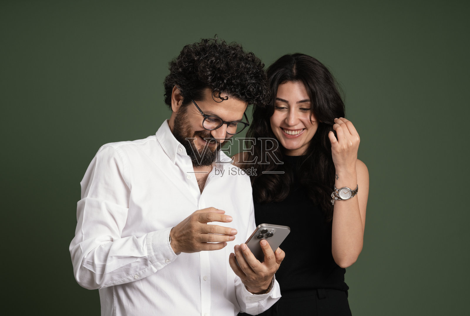 幸福的夫妇使用智能手机，绿色背景照片摄影图片