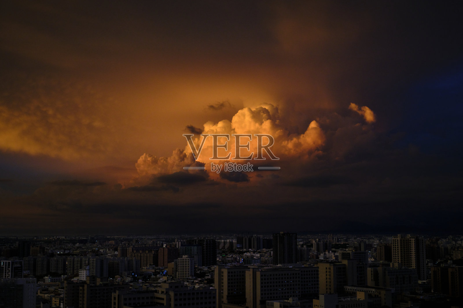 在大雨来临之前，城市美丽风景摄影的天际线日落。大自然的天空充满了云彩。一边是彩云，一边是乌云。照片摄影图片