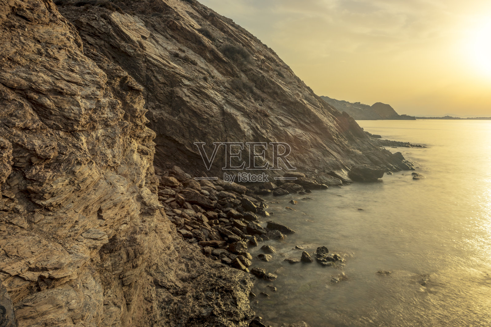 在穆尔西亚地区阿吉拉斯的阿马里拉海滩上，日出时令人惊叹的岩石悬崖照片摄影图片