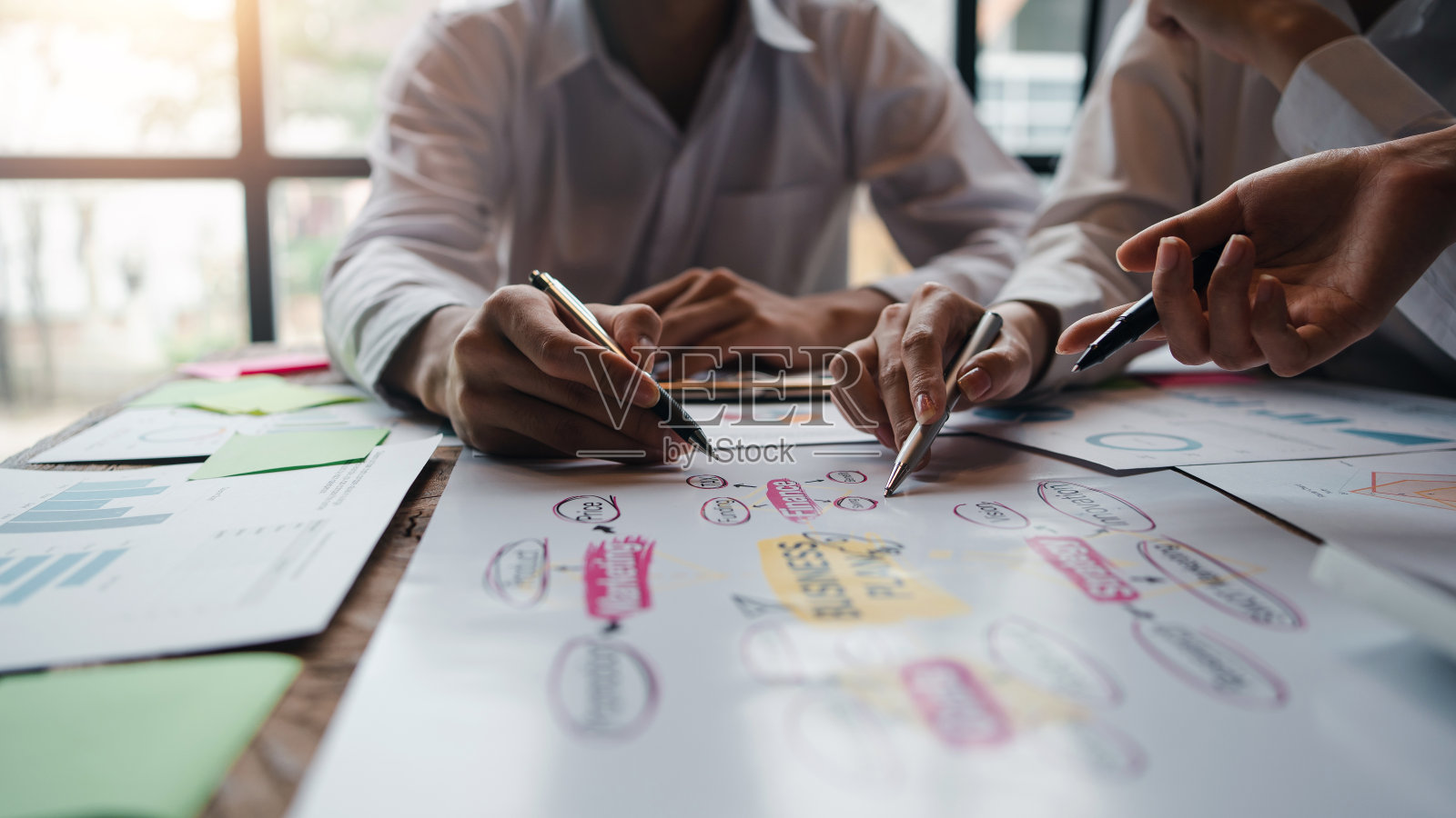 努力工作的商人通过展示图表作为一个团队一起工作。并绘制各部门工作图表，在会议上共同提出和讨论报告。照片摄影图片