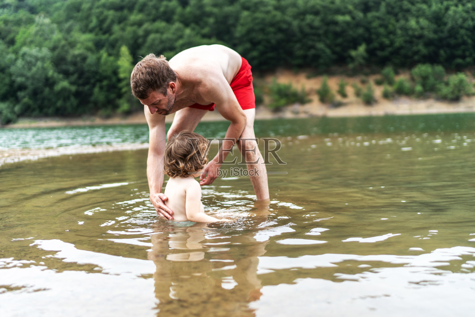 可爱的孩子和她爸爸在湖里玩得很开心照片摄影图片