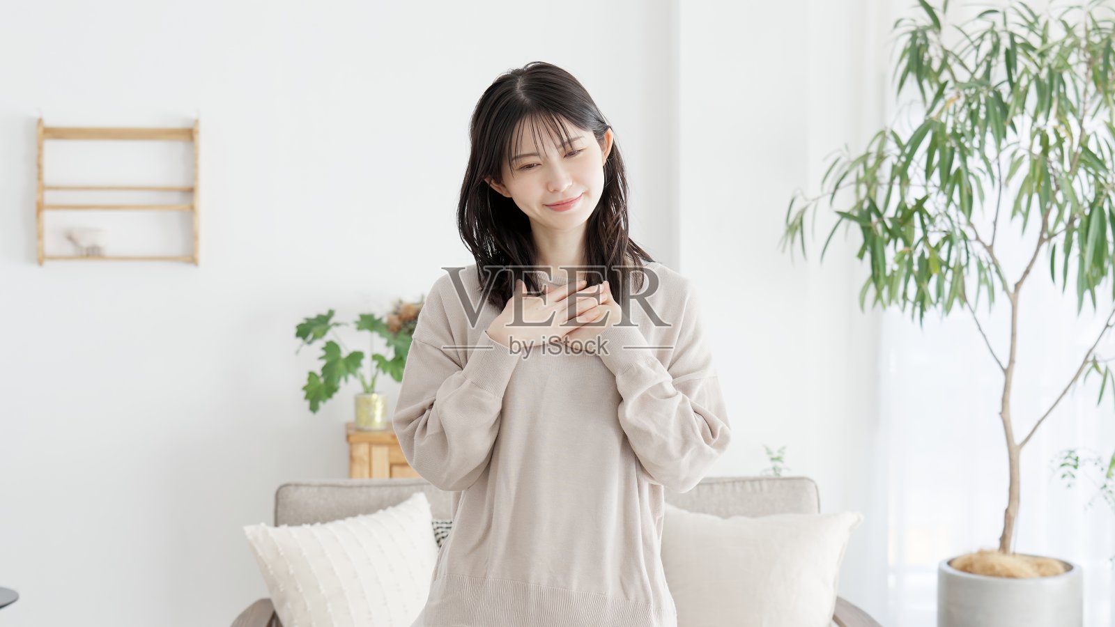 双手放在胸前感到快乐的女人照片摄影图片