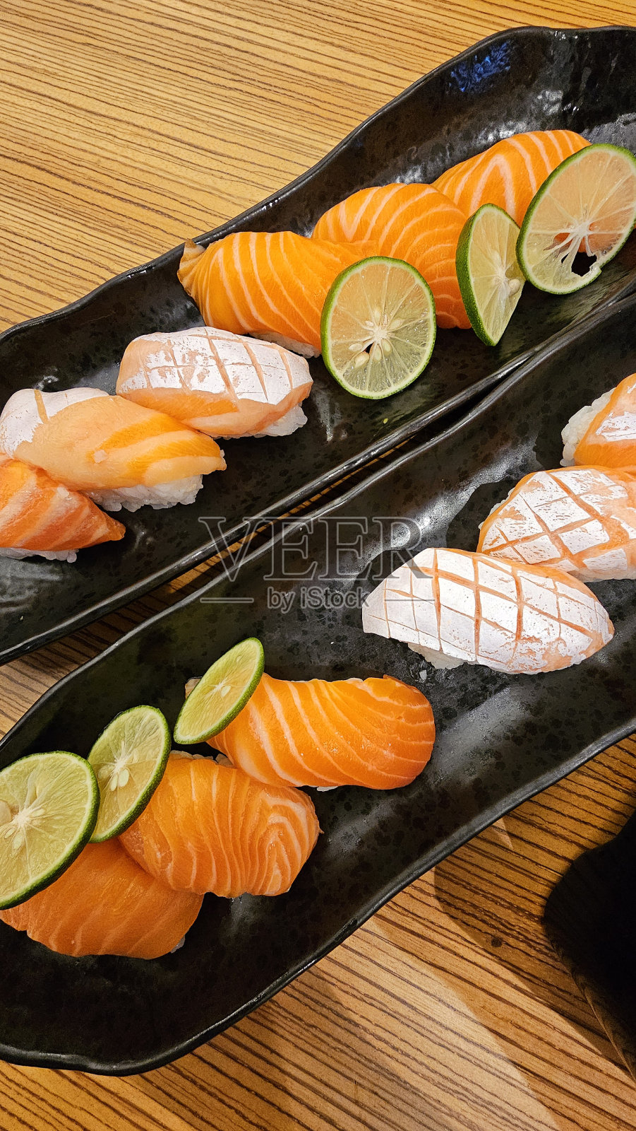 寿司店的木桌三文鱼寿司。照片摄影图片