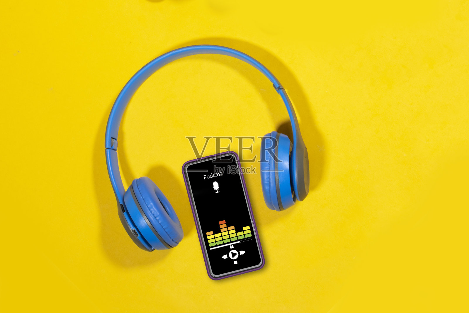 播客的背景。手机屏幕上有播客应用，手上有女人声音的耳机照片摄影图片