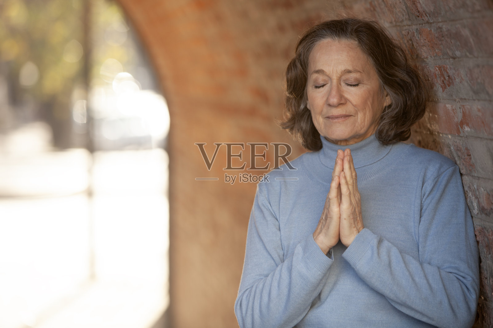 老妇人在街上沉思照片摄影图片