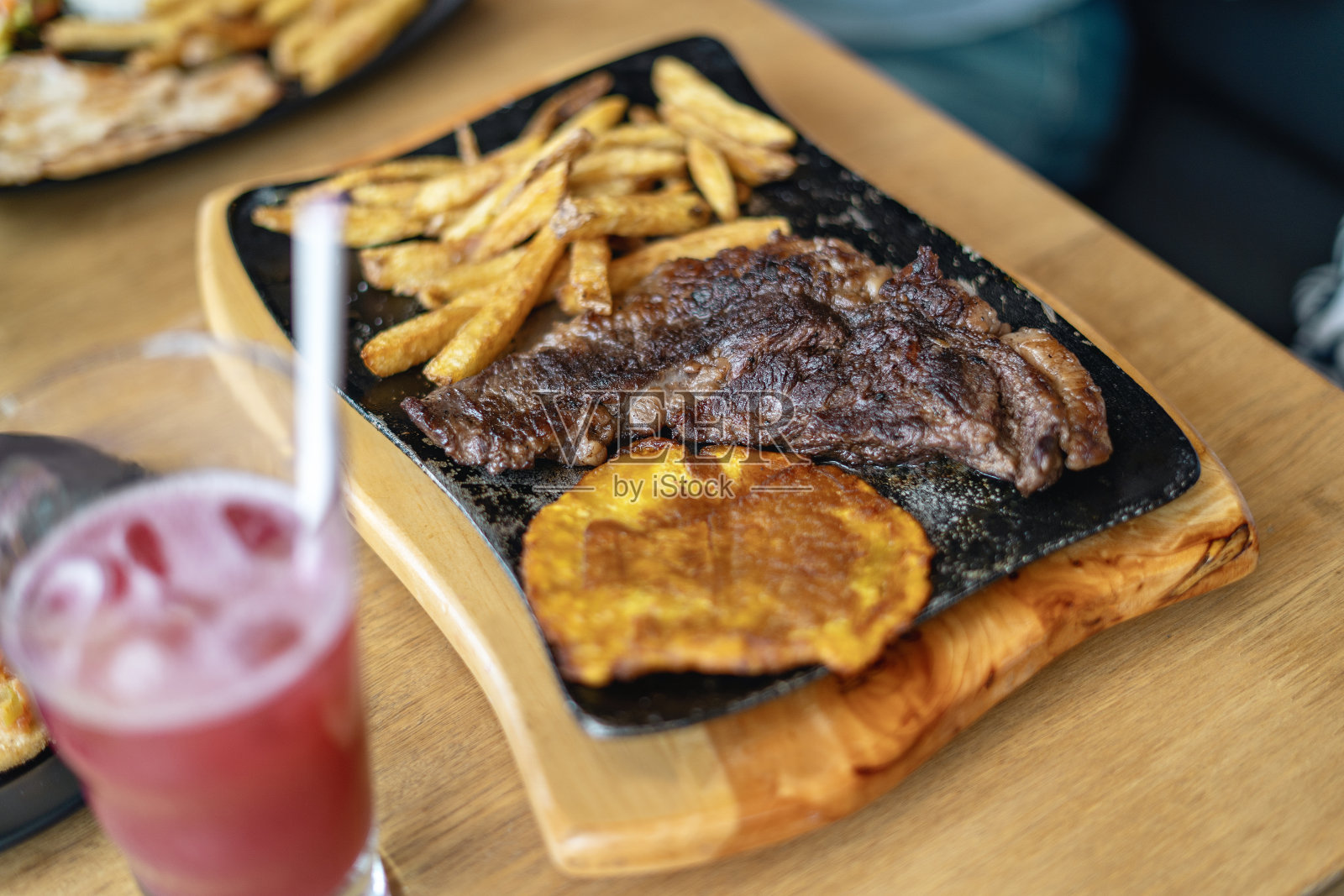 餐馆里桌子上的一盘牛排。照片摄影图片