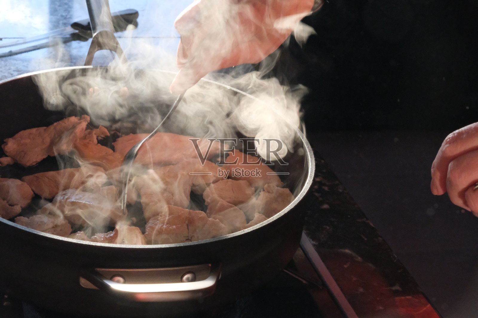 在灶台上煮肉的人照片摄影图片