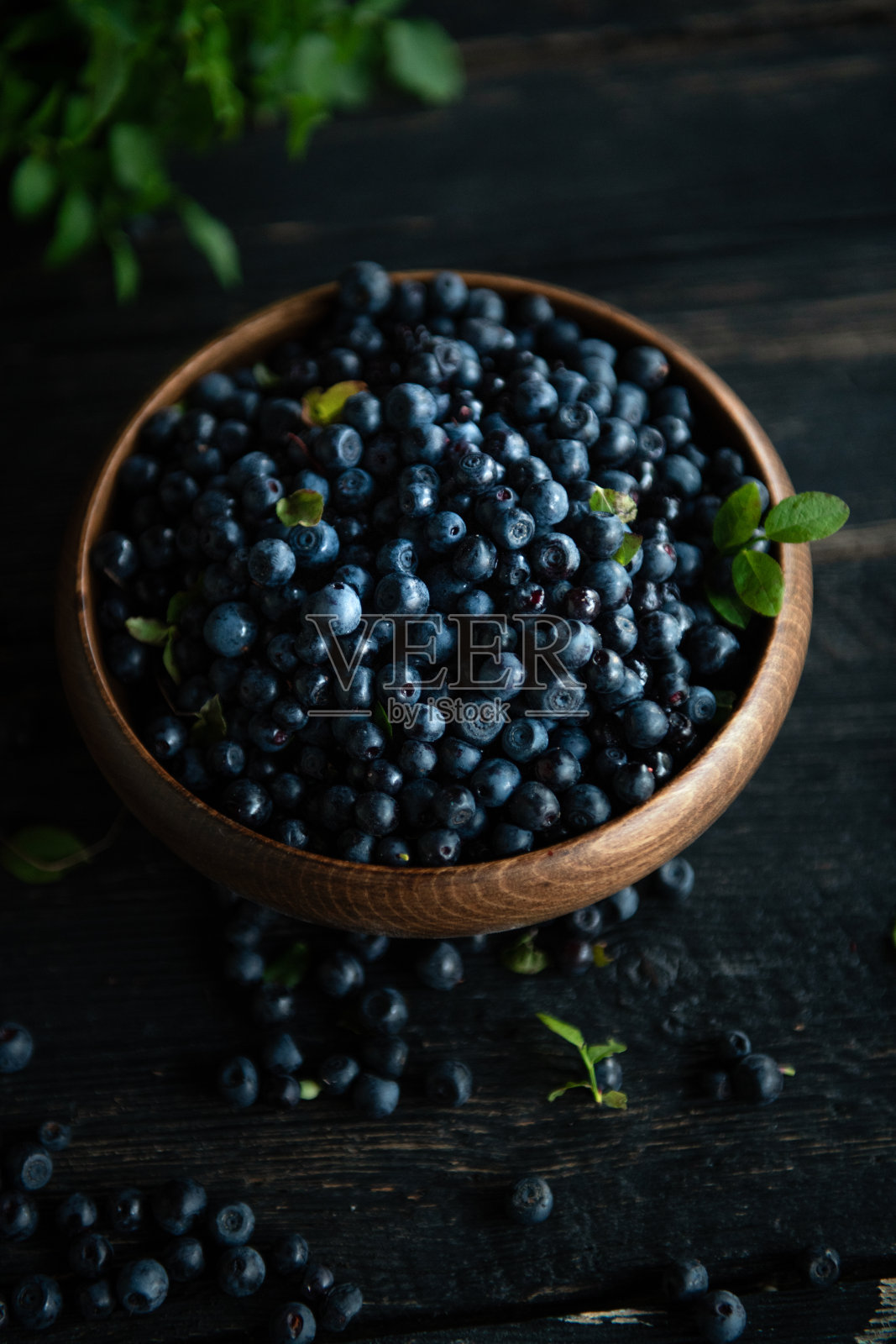 新鲜的野生浆果放在桌子上的碗里照片摄影图片