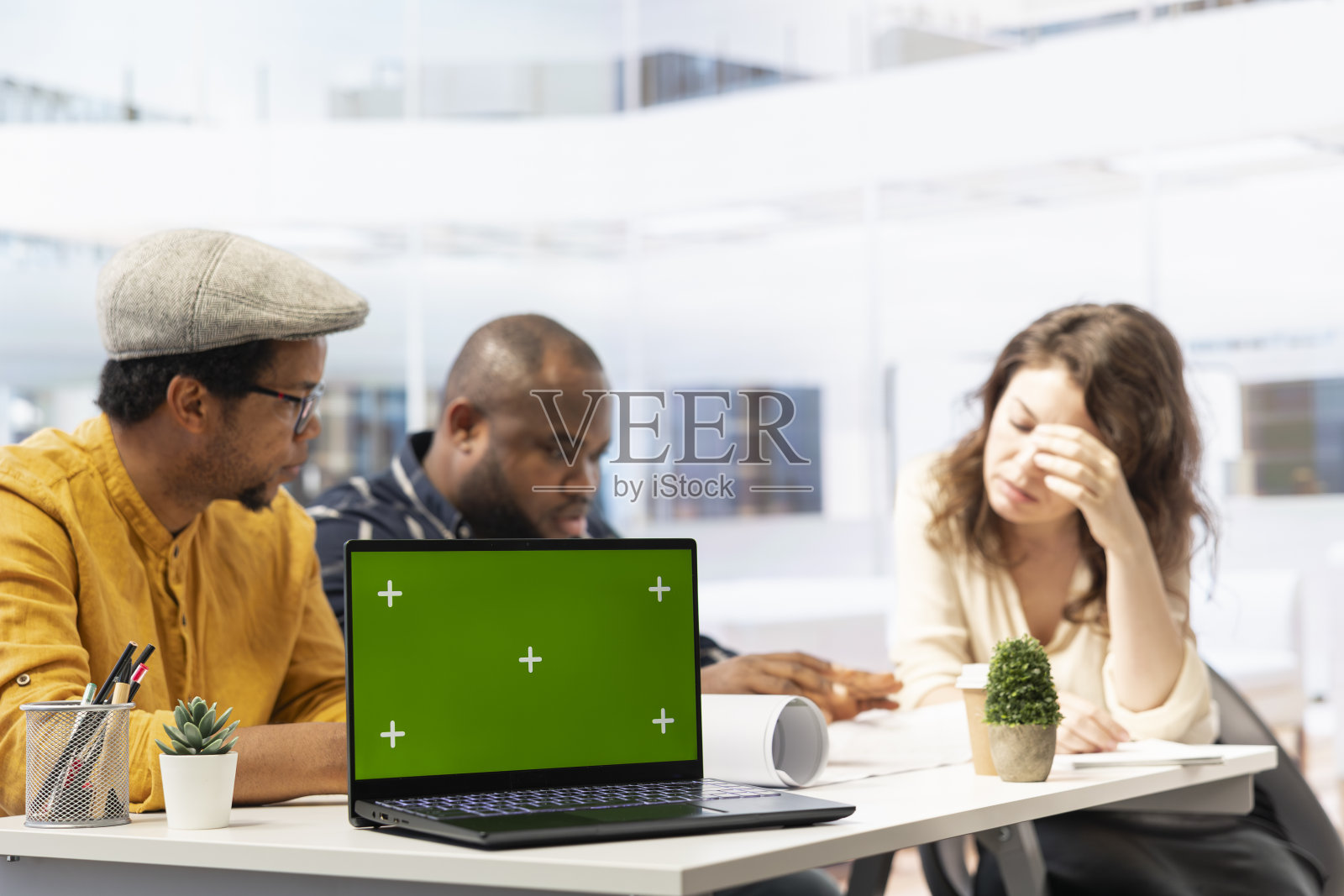 房地产经纪人和客户在绿色屏幕旁检查蓝图照片摄影图片