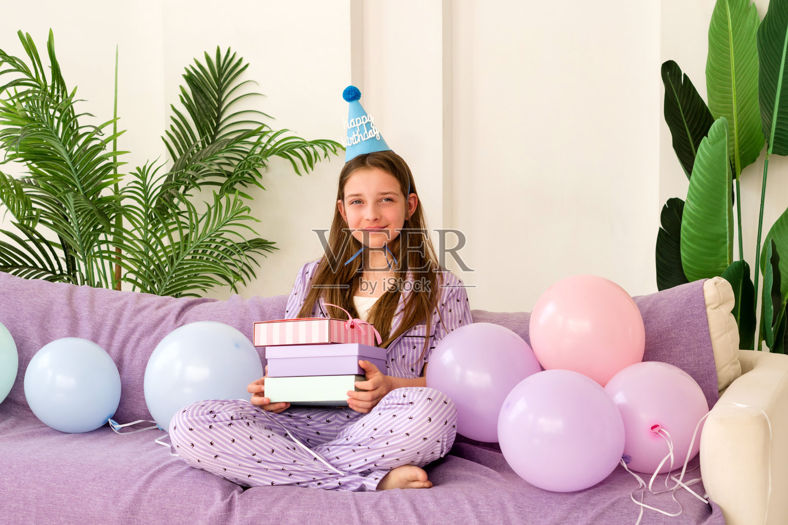 女孩在她的生日拿着带气球的礼物。照片摄影图片