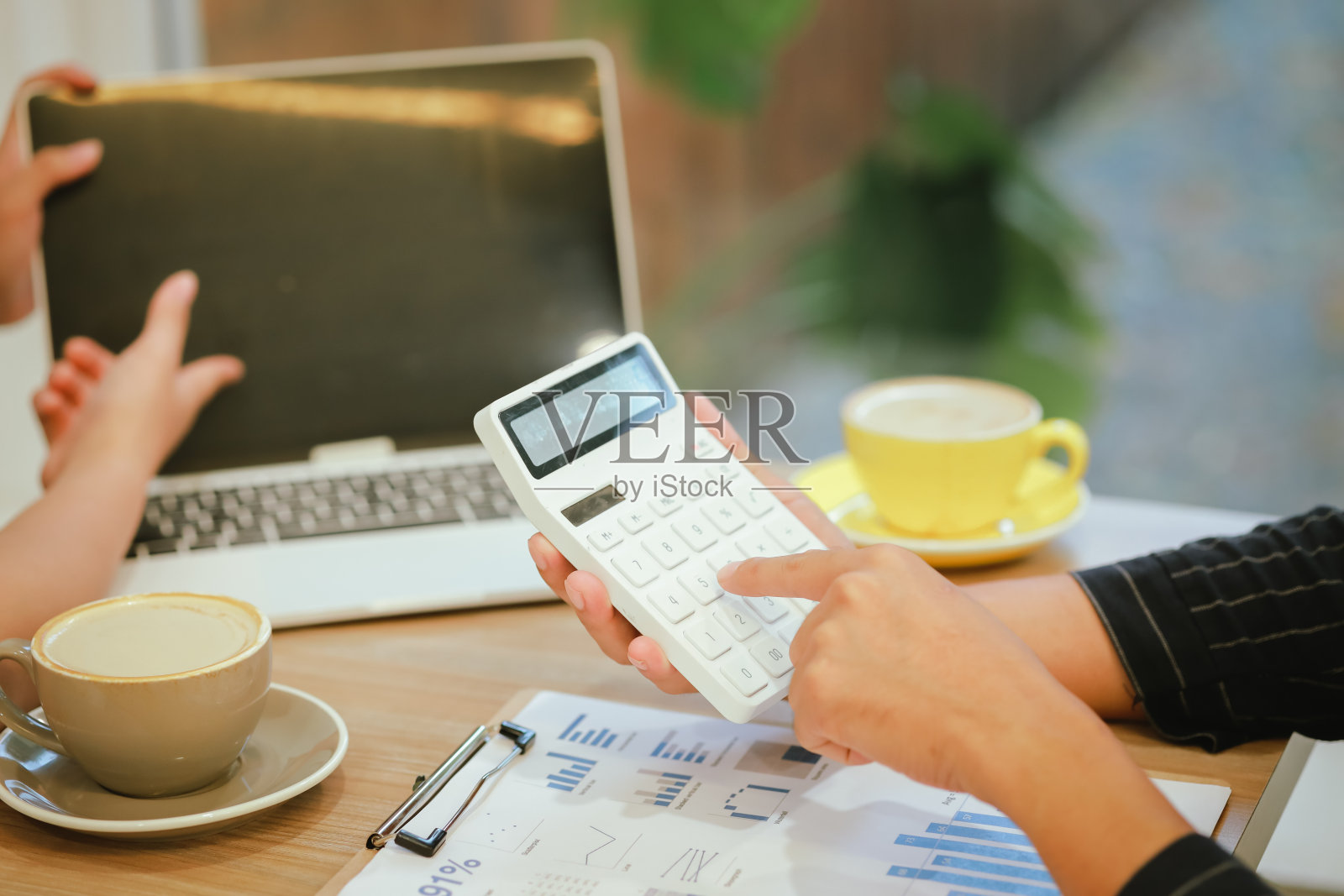 亚洲男人和女人，在咖啡馆享受早上的会议，拿着一杯热拿铁，在一个愉快，轻松的氛围中，背景模糊。照片摄影图片