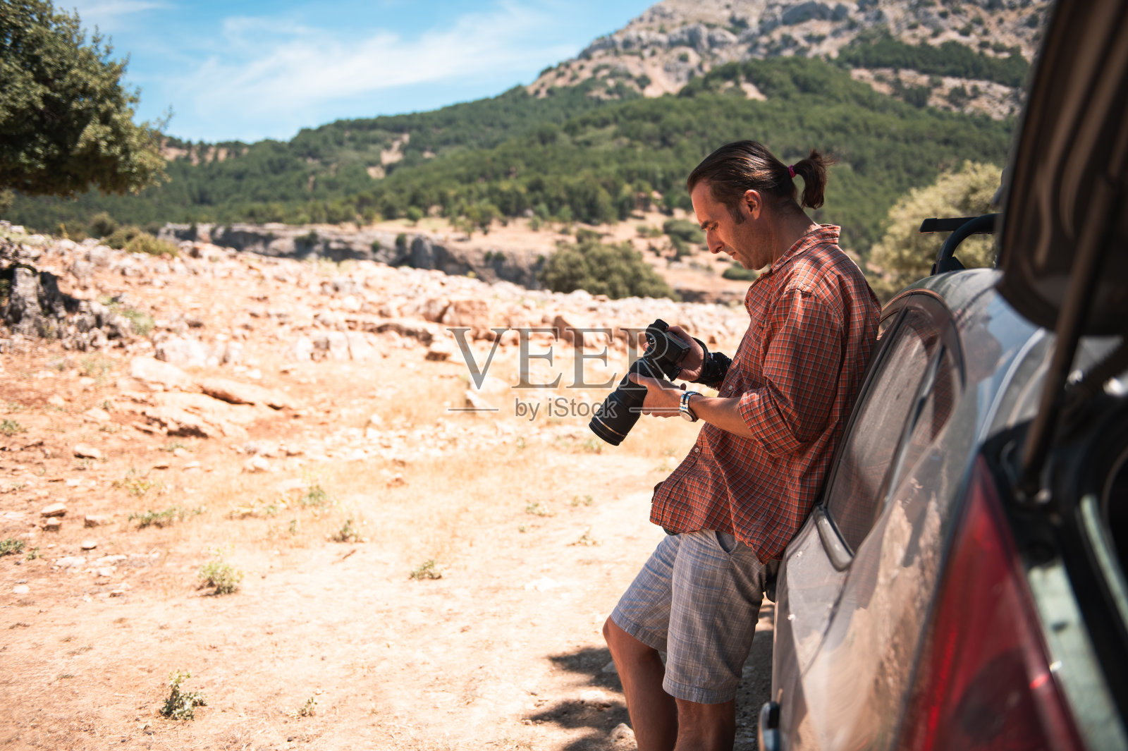 摄影师在风景优美的户外旅行中回顾相机照片摄影图片
