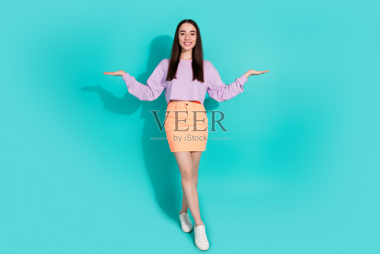 迷人的年轻女子的全尺寸照片比较hold空穿着时髦的紫色衣服孤立在海蓝宝石的背景照片摄影图片