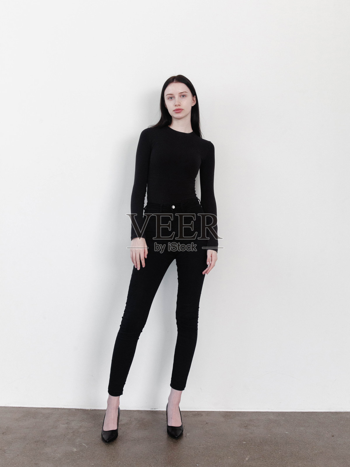 美丽的年轻苗条的女人全身写真时尚模特工作室拍摄的白色背景穿着全黑衣服长袖上衣紧身牛仔裤裤子高跟鞋鞋素颜看起来自信惊人华丽的自然美梦想的身体目标照片摄影图片