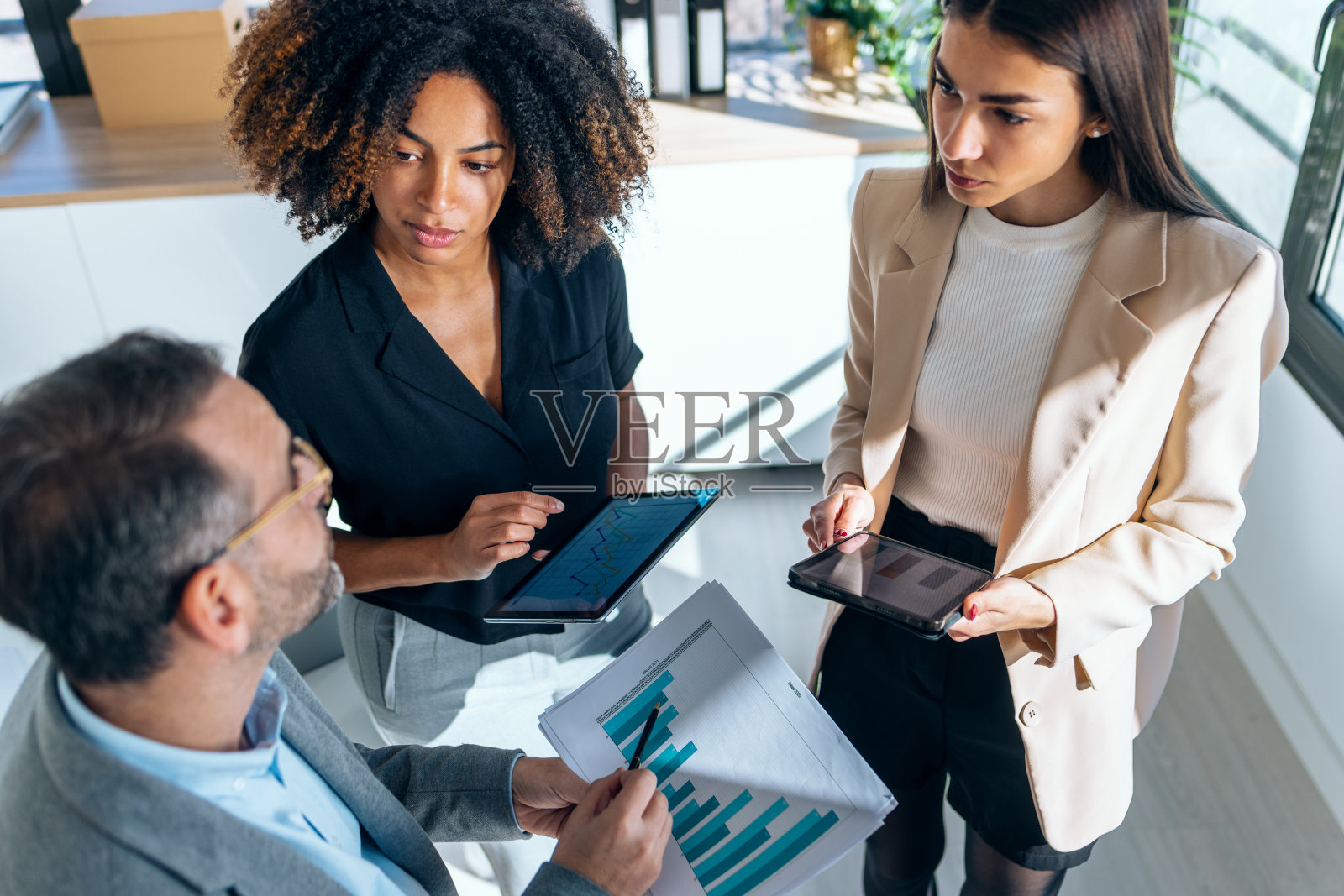 优雅的多年龄段的商务人士在办公室一起工作和谈论他们的新项目。照片摄影图片