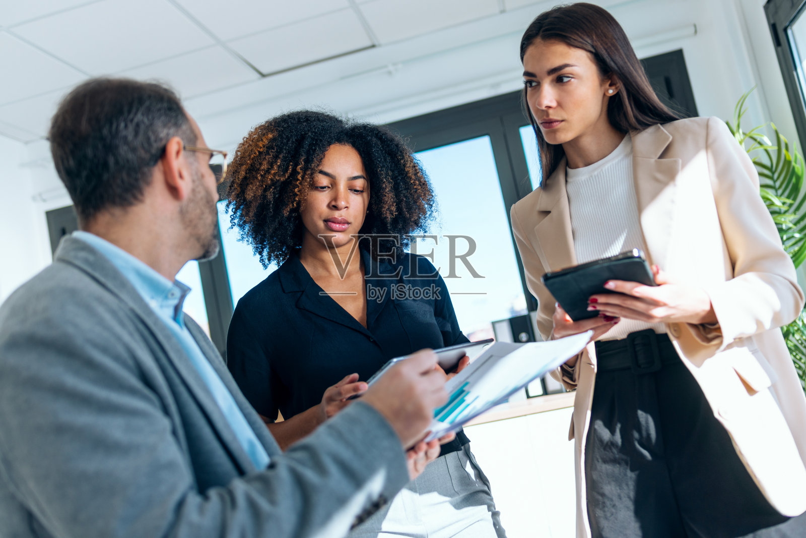 优雅的多年龄段的商务人士在办公室一起工作和谈论他们的新项目。照片摄影图片