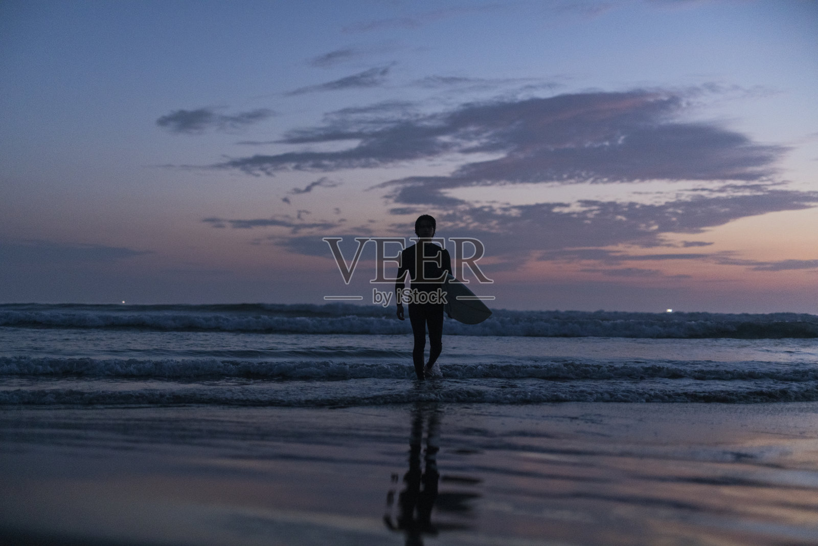 人们在黎明冲浪。照片摄影图片