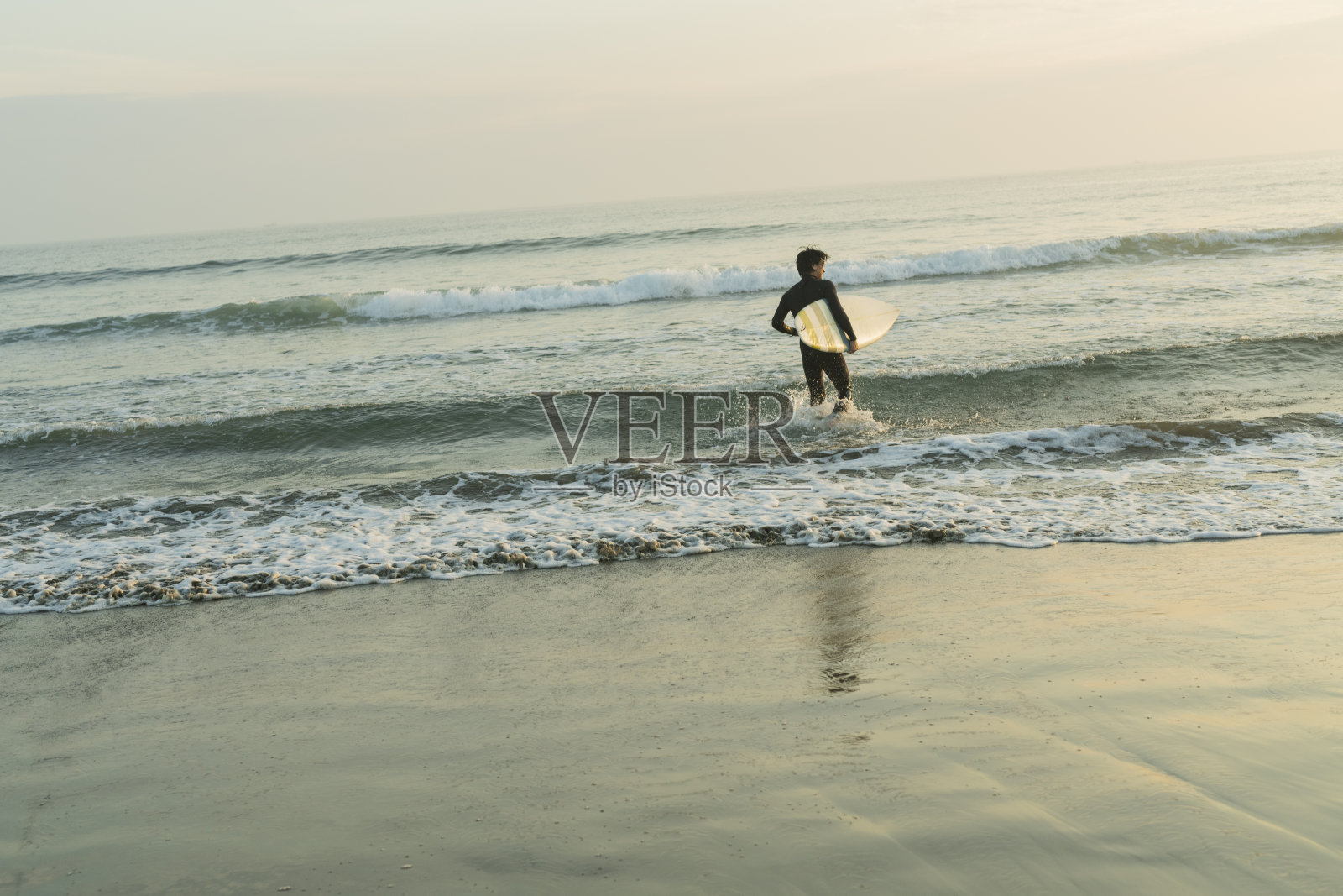 男子在清晨的海洋中冲浪。照片摄影图片
