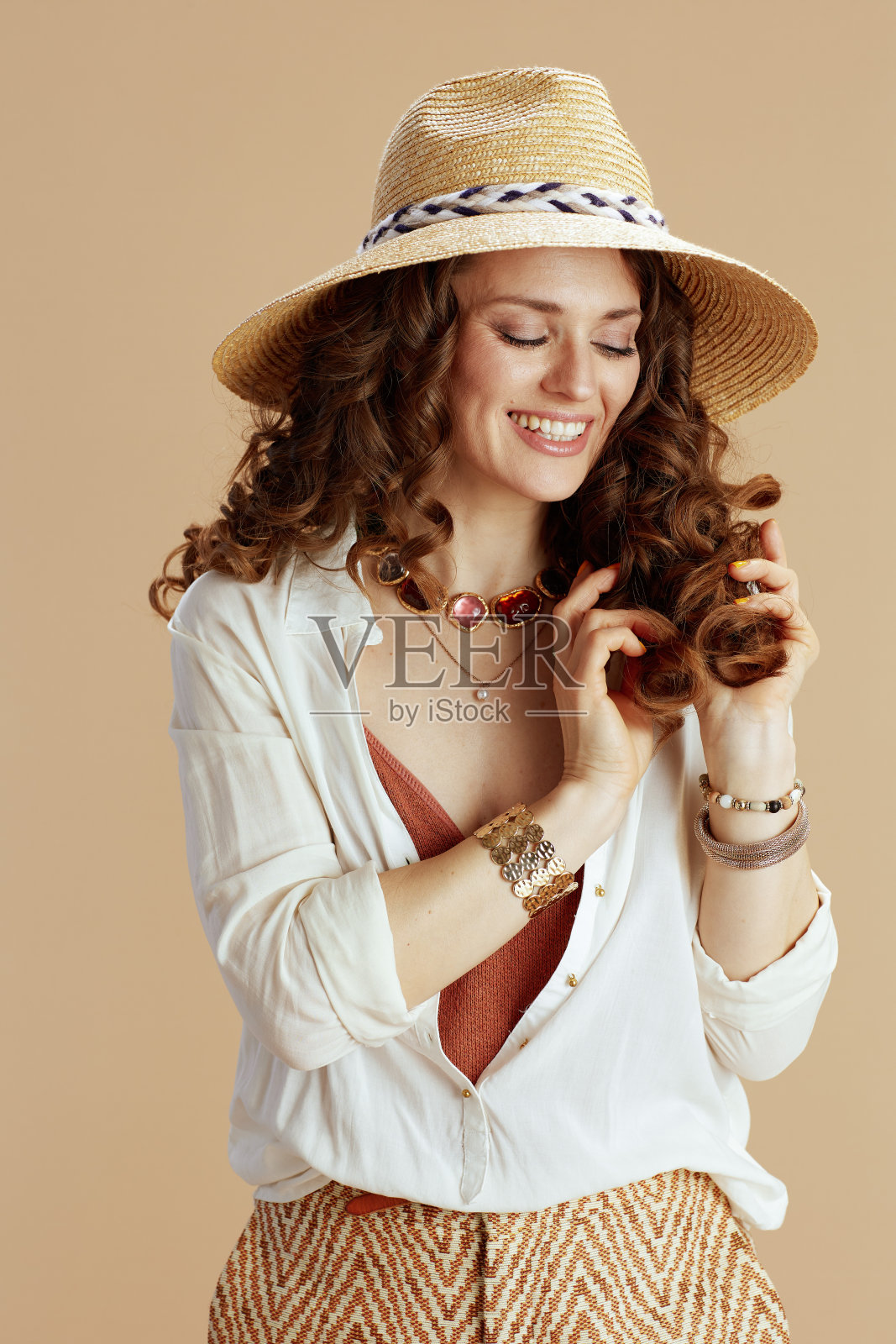 穿着米色上衣和短裤微笑的时髦女人照片摄影图片