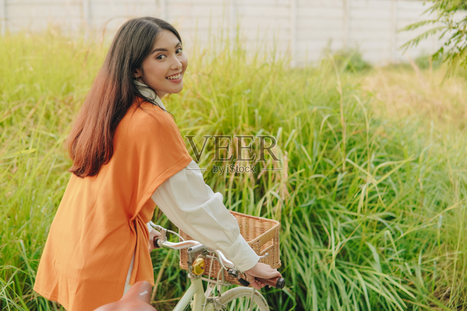 漂亮的亚洲女人骑着自行车在附近散步。照片摄影图片