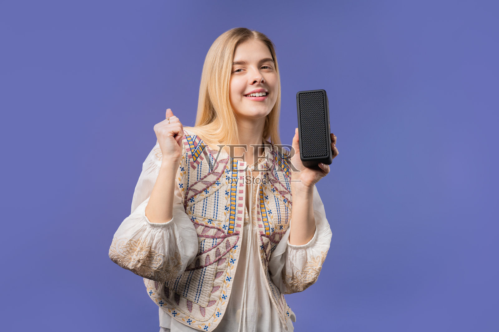 金发女子听音乐的无线便携式扬声器音响系统，紫罗兰照片摄影图片